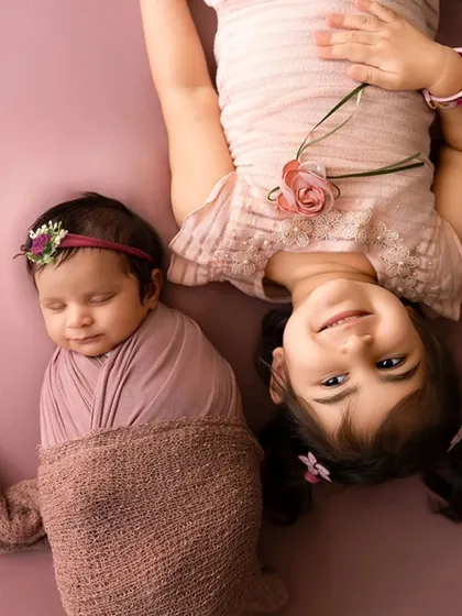 A tender moment between a sleeping newborn, snugly wrapped, and her loving older sister. I welcome siblings to be part of the photoshoot to capture these precious family bonds.