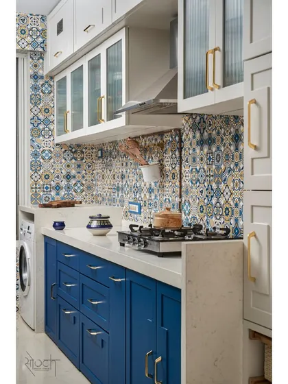 A full view of the kitchen, showing the ivory overhead storage, Moroccan tile backsplash, and royal blue base cabinets.