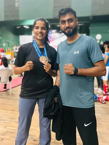 Another proud coach-student moment, celebrating a significant achievement at the state championship. This partnership is key to turning potential into performance.