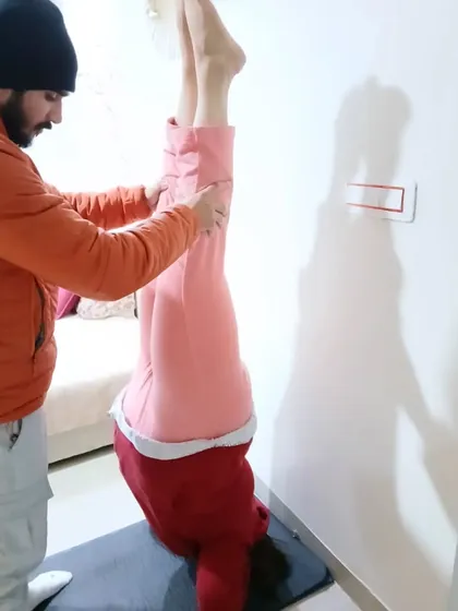 Wall-assisted handstands are a great way to build strength. My role here is to ensure proper form and prevent the student from collapsing.