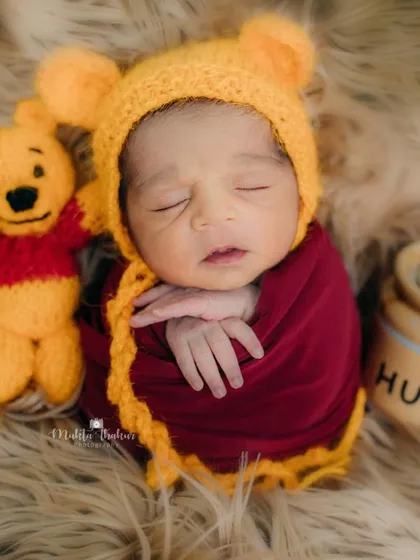 This little Pooh bear is dreaming of honey. Themed newborn sessions like this are a fun way to celebrate your family's favorite stories.