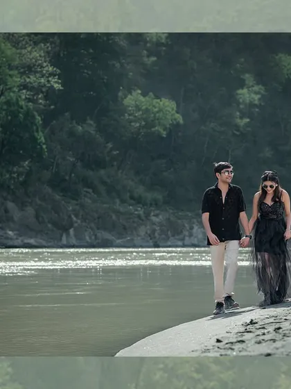 A stylish walk along the water's edge. The bride's black flowing dress adds a touch of elegance and drama to the rustic, natural beauty of the riverside.