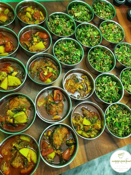 A large batch of fried fish curry and singju, prepared in individual steel bowls for an event.