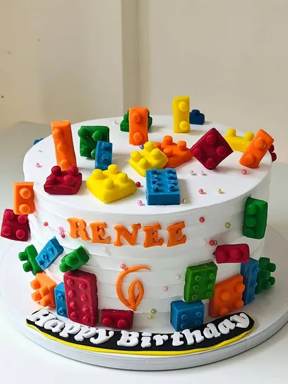 Building a fun birthday with this Lego-themed cake. It's covered in colorful, edible Lego blocks made from fondant, creating a playful and interactive dessert that kids absolutely love.