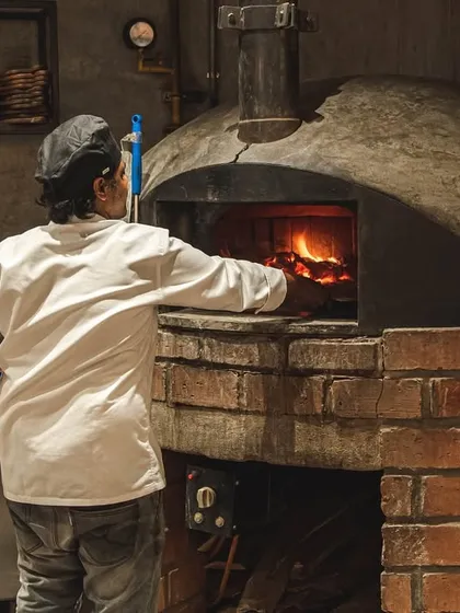 Tending the flames is an art. Our chefs maintain the perfect temperature in our custom-built brick ovens, ensuring every pizza that comes out is consistently delicious.