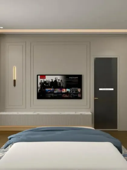 The TV wall in this blue-themed bedroom features elegant molding and a built-in display shelf, combining classic and modern design elements.