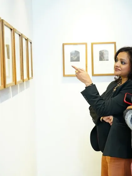 Two visitors discussing a series of framed albumen silver prints. We love seeing people take a closer look and share their interpretations of the art.