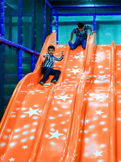 Two friends racing down the wide slide. The design allows for safe, side-by-side fun.