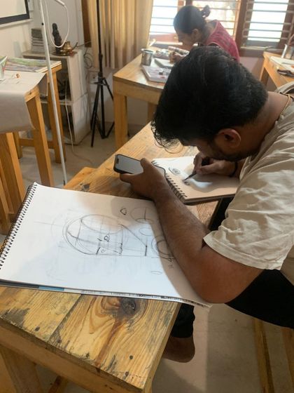 A student in our charcoal course works on perspective and form exercises before tackling a full portrait.