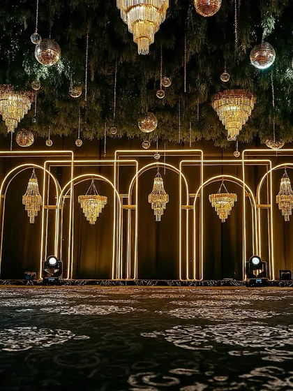 This is what we mean by 'Met Gala style'. For this Sangeet, we designed a modern, architectural backdrop with clean neon arches and dramatic crystal chandeliers, setting the stage for a high-energy night of glamour and celebration.