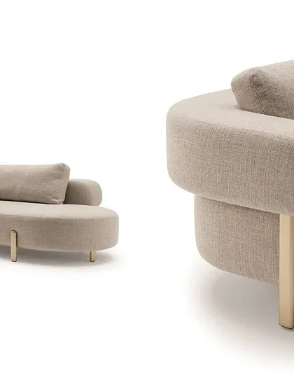 A detailed view of the Roman couch, showing the plush armrest that extends along the perimeter and the elegant metal leg, highlighting the purity of its rounded form.