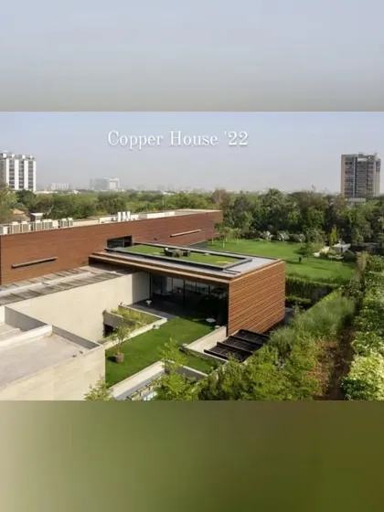 The completed Copper House project, showing how the landscape has matured. The rooftop gardens and green lawns integrate the building into its lush surroundings.