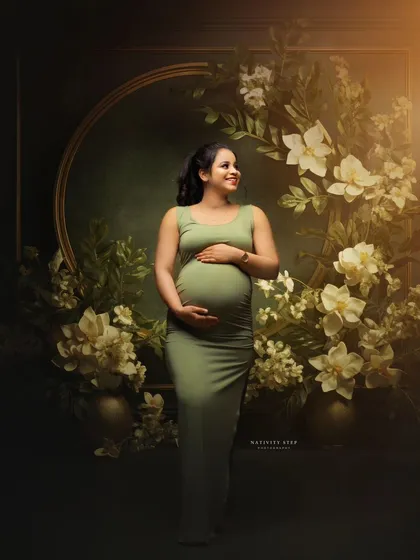 A beautiful studio portrait with a stunning floral arch. The mother-to-be's simple green dress is perfectly complemented by the elaborate setup.