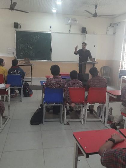 An instructor at a lectern teaches a class, using a whiteboard to illustrate key concepts during a workshop.