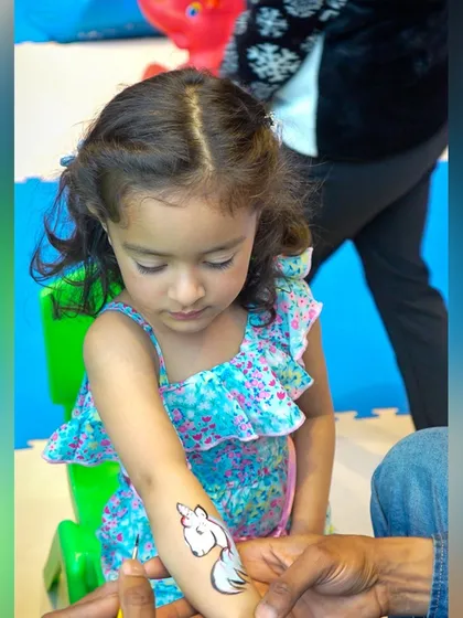 A guest gets a temporary unicorn tattoo, one of the many fun activities offered at our themed parties.