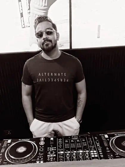 Confidence is not arrogance; it's belief in oneself. A black and white shot from behind the decks, feeling confident and ready.