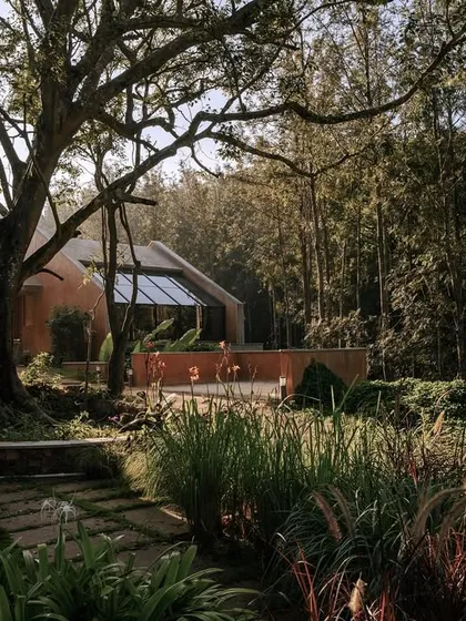 A view of the resort's architecture nestled within a lush, wooded landscape. The image showcases how the buildings are thoughtfully integrated into the natural environment, creating a harmonious retreat.