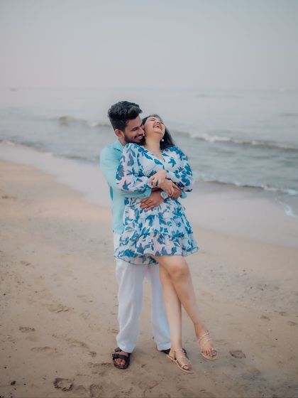A moment of pure, uninhibited joy on the beach. He lifts her up in a playful embrace, and her laughter is the centerpiece of this candid and heartwarming pre-wedding photograph.