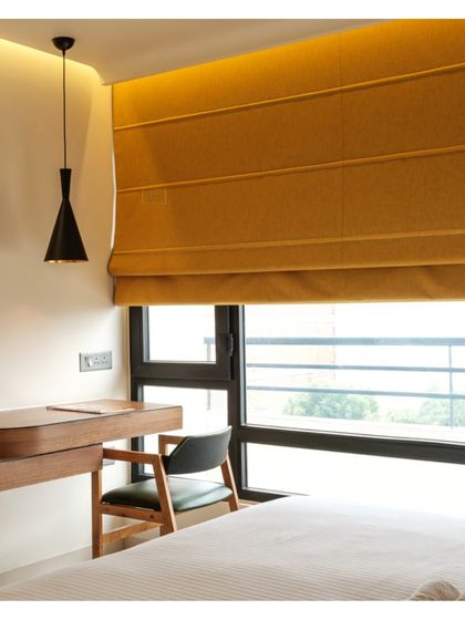 A cozy corner by the window provides a perfect spot for guests to relax and enjoy the view. The clean lines of the furniture are softened by the warm color palette.