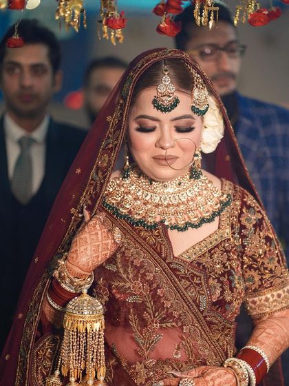 A beautiful close-up of the bride looking down, showcasing her intricate jewelry, makeup, and the delicate details of her wedding dress.