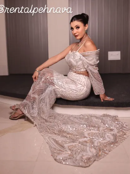 A seated pose in the white and silver gown, showcasing the long, dramatic trail.