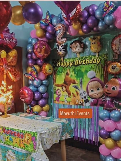 A cozy Masha and the Bear themed party. This setup includes a character backdrop, a themed tablecloth, and colorful balloon columns.