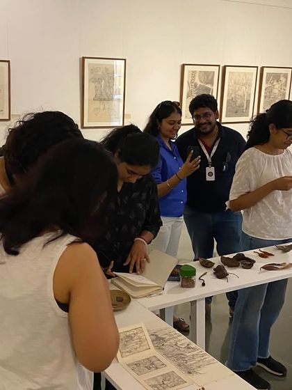The MAP team gathered around one of the tables, discussing the artist's books and small objects.