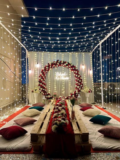 This shot shows the full length of the low seating arrangement under the fairy light canopy, perfect for an intimate gathering with friends and family.