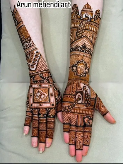 A unique design featuring interlocking wedding rings on one hand and a full bridal-style pattern with peacocks and a palace on the other.