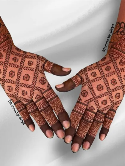 A full-coverage grid mehendi for the back of the hands. The diamond-shaped grid is filled with small floral motifs, creating a rich and textured design.