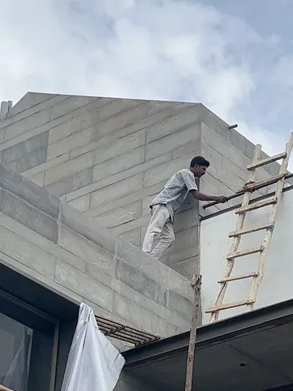 A craftsman at work on the stone facade of a residential project. We believe in the importance of craftsmanship and work closely with skilled artisans to bring our architectural details to life.