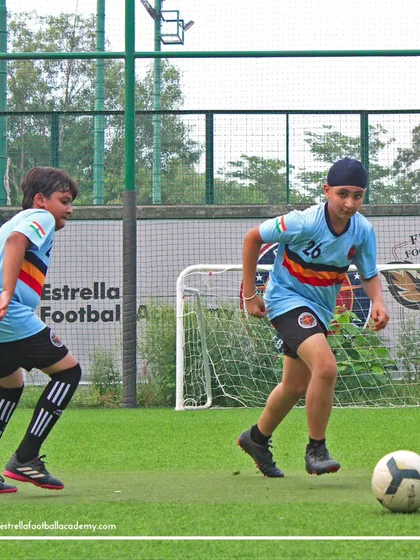 Two players practice dribbling and defending in a close-quarters drill, improving their skills under pressure.