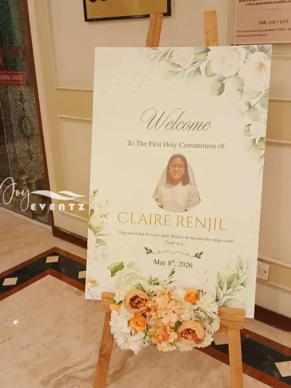 A personalized welcome board for a First Holy Communion. We designed this sign with a soft, floral watercolor theme and a photo of the child, displayed on an easel with a matching flower arrangement.