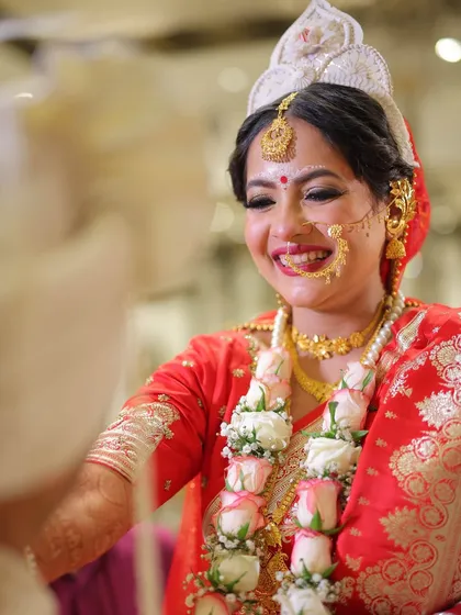 There is nothing more beautiful than a bride's genuine smile. Here is my gorgeous Bengali bride, Anamika, sharing a joyful moment during her wedding ceremony. I focused on a timeless look with a radiant base and classic red bindi.