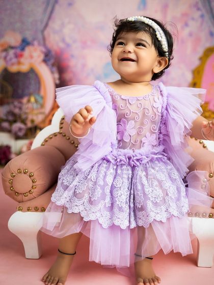 The purest smile from our little princess. The soft lighting and delicate lace dress create an angelic portrait that parents will cherish forever.