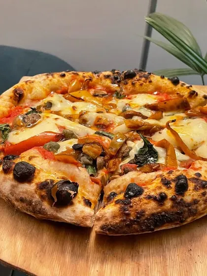 A delicious looking pizza fresh off the peel from my pizza lab. The beautiful leopard spotting on the crust shows the result of experimenting with fermentation and baking techniques.