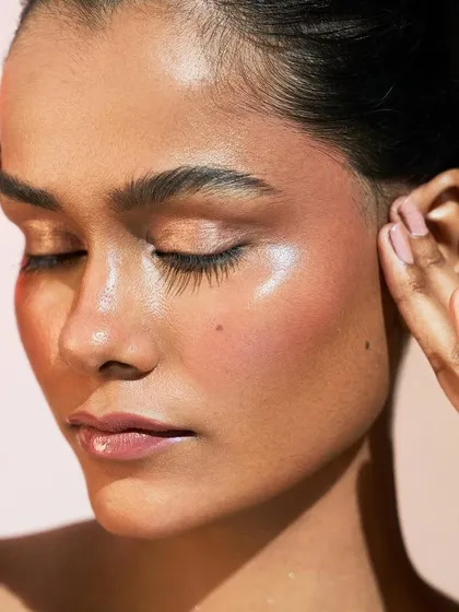 This image captures the beautiful texture of glowing skin. The highlight is not glittery, but rather a natural-looking sheen that mimics healthy, hydrated skin.