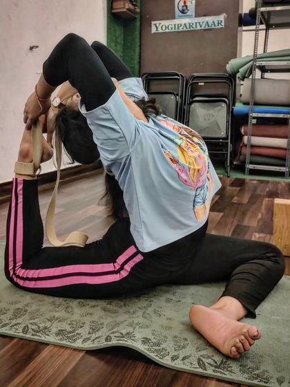 A student uses a strap to assist in Eka Pada Rajakapotasana, a technique we teach to make advanced poses more accessible.