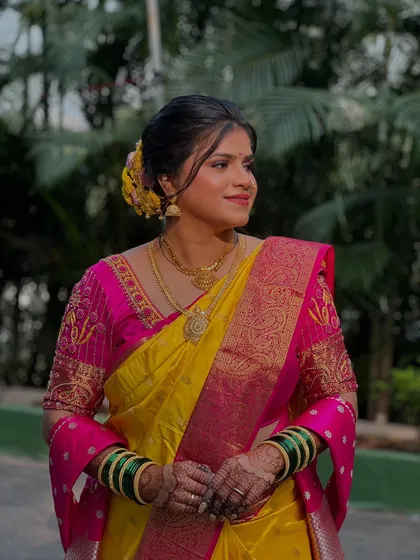 My bride Krutika looking stunning in her yellow and pink saree, with makeup that perfectly complements the vibrant colors.
