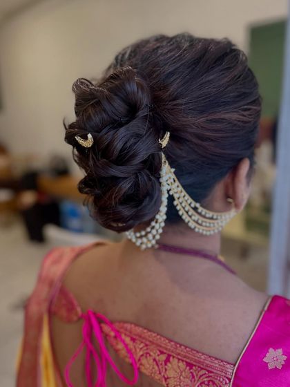 A side view of the braided bun, showcasing the beautiful texture and the way the pearl accessory drapes gracefully around the updo. This is a perfect style for a reception or engagement.