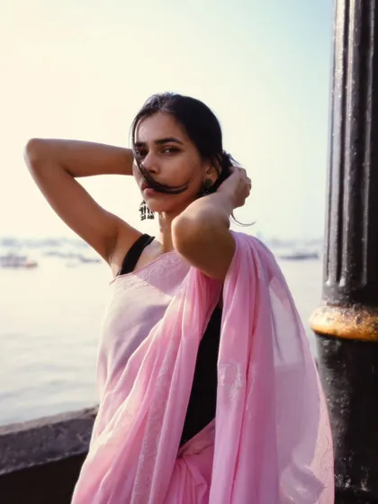 A playful moment with hair blowing in the sea breeze. This candid shot captures the carefree vibe of being by the Mumbai seaside.
