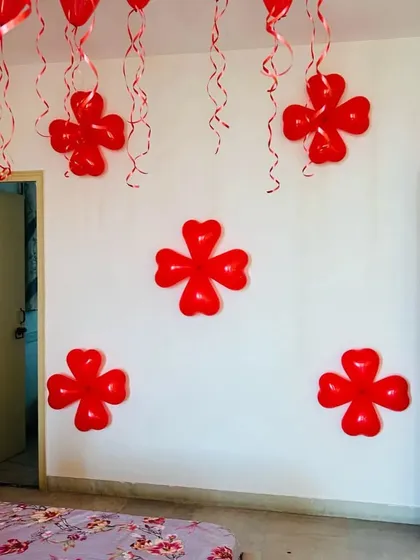 This photo shows the simple flower-shaped balloon clusters made from red heart balloons. These small details can be added to any wall to enhance the decoration.