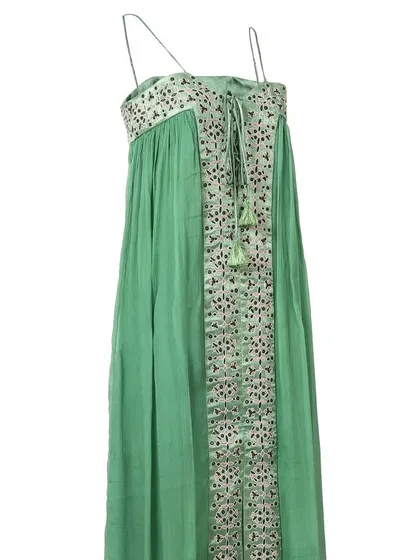 A side-angle view of the green embroidered maxi dress, showing the flow of the fabric and the tie-up detail at the neckline.