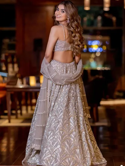 A full-length shot capturing the glamour of her reception outfit. The soft, flowing hair and radiant makeup complete this stunning look.