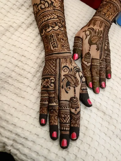 A beautiful design for Diwali, featuring peacocks and jhumkas. The bright pink nails add to the festive look.