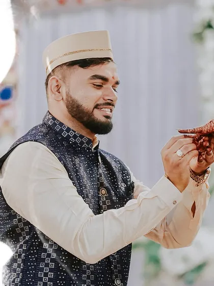 A beautiful moment during an engagement ceremony where the groom-to-be gently holds his fiancée's hand, showcasing the newly exchanged ring.