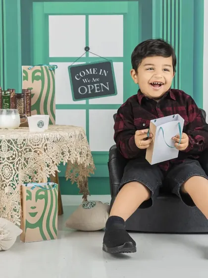 This little boy is all smiles during his Starbucks-themed session, ready to take your order.