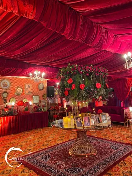 The centerpiece of a lavish, red-themed engagement party. This grand floral arrangement and photo table set the tone for an evening of opulent celebration.