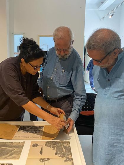 Curator Pushpamala N. showing details in the Vrishchik art magazine to the artist.