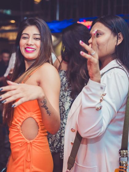 A stylish guest in an orange dress enjoying the party.